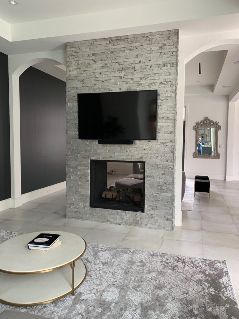 TV mounted above fire pit on a grey brick wall