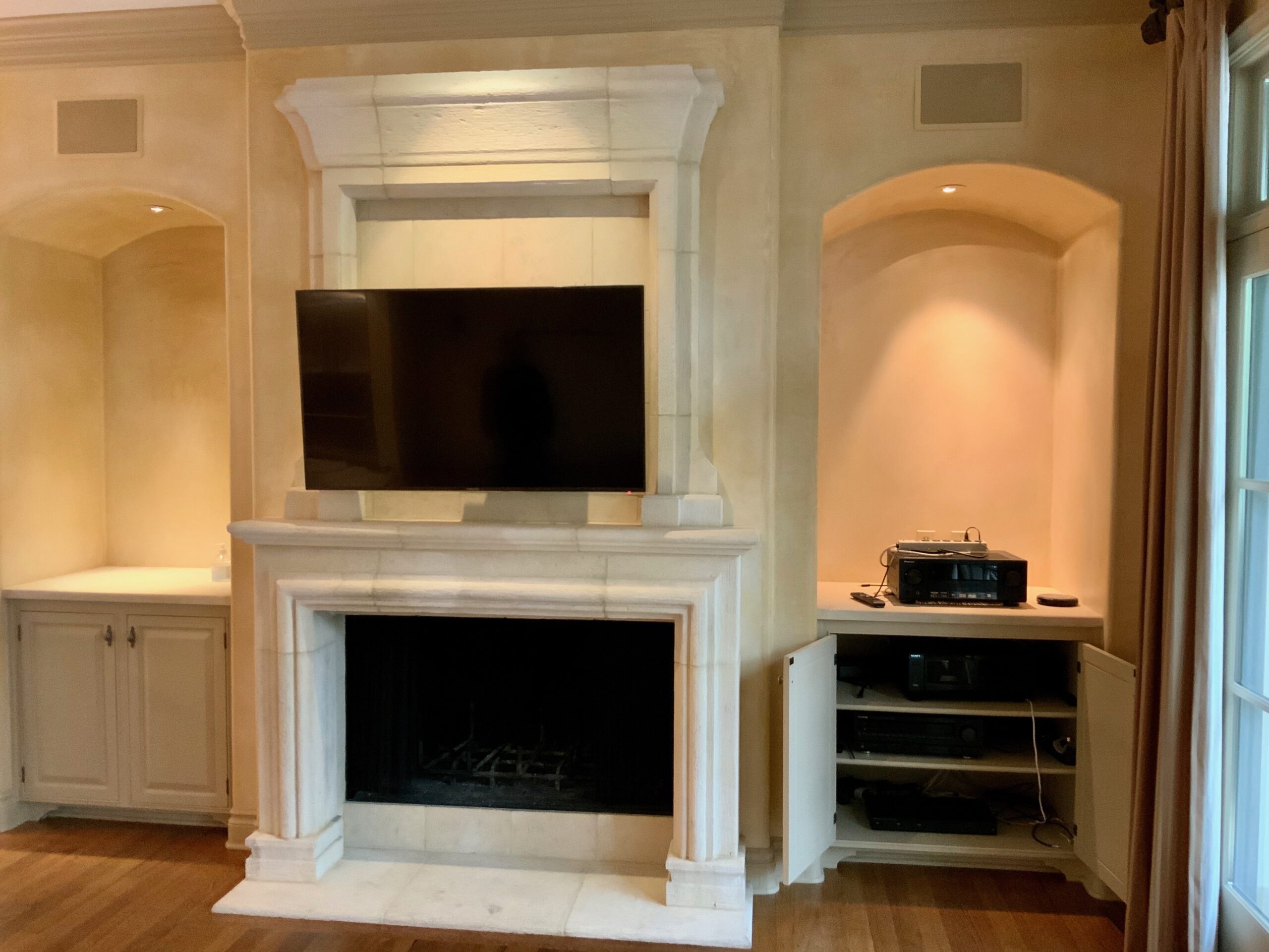 Fireplace TV mounted above with integrated surround sound system