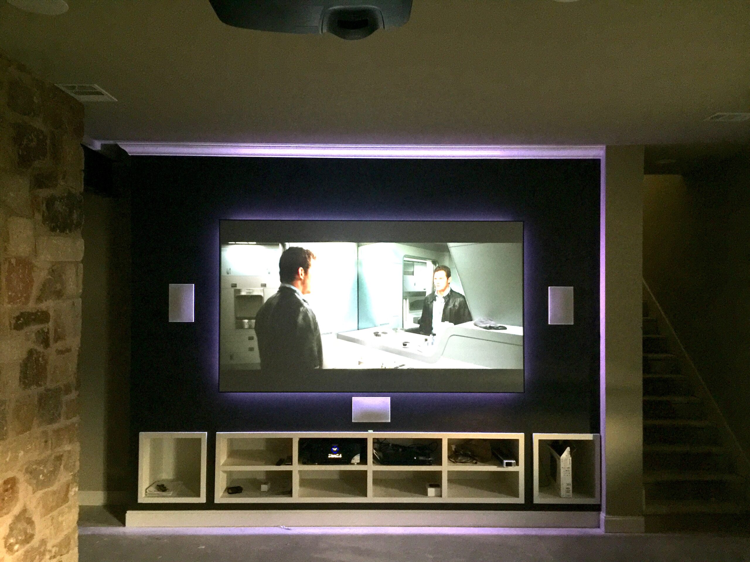 Home theater room with short throw laser projection, hidden pristine sound system and interior theater lighting