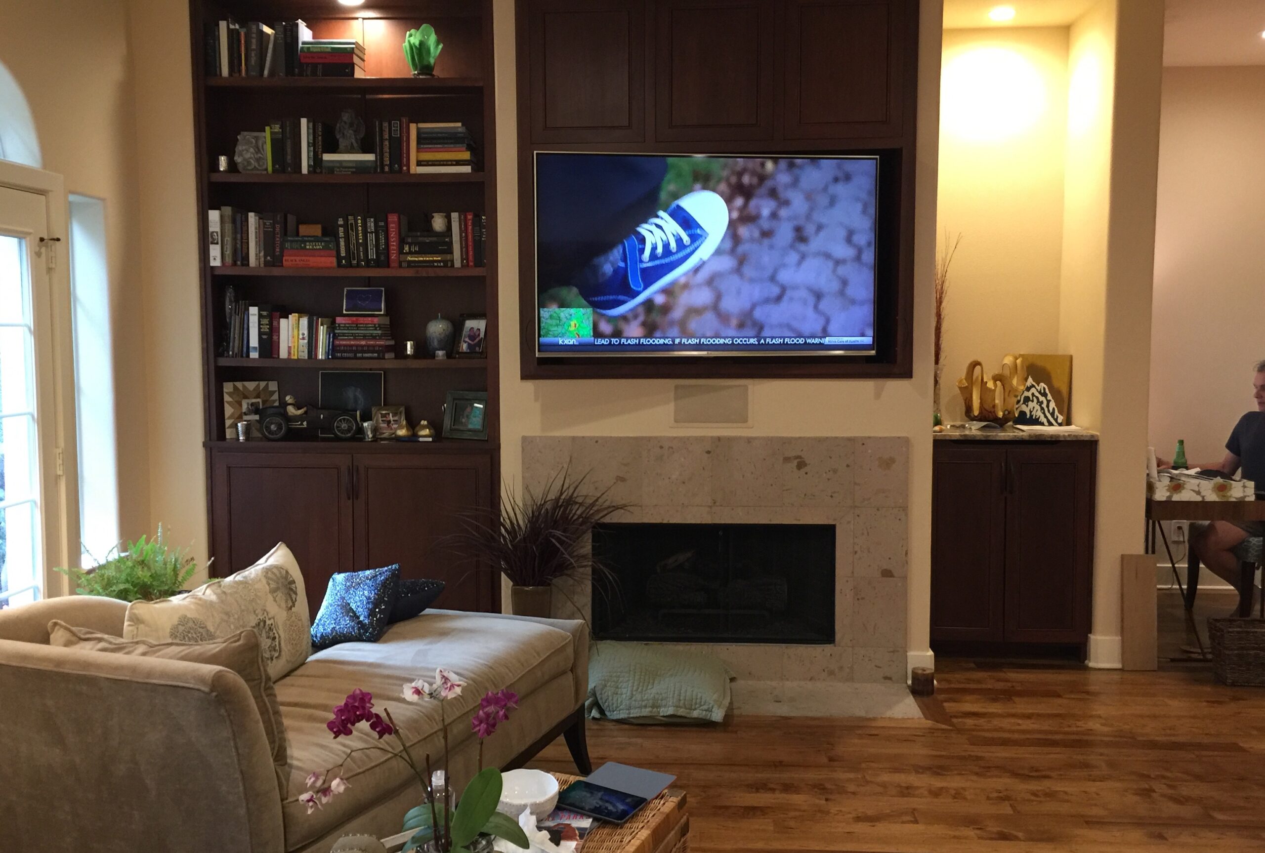 Media room with hidden speakers and TV installed in wall above fireplace